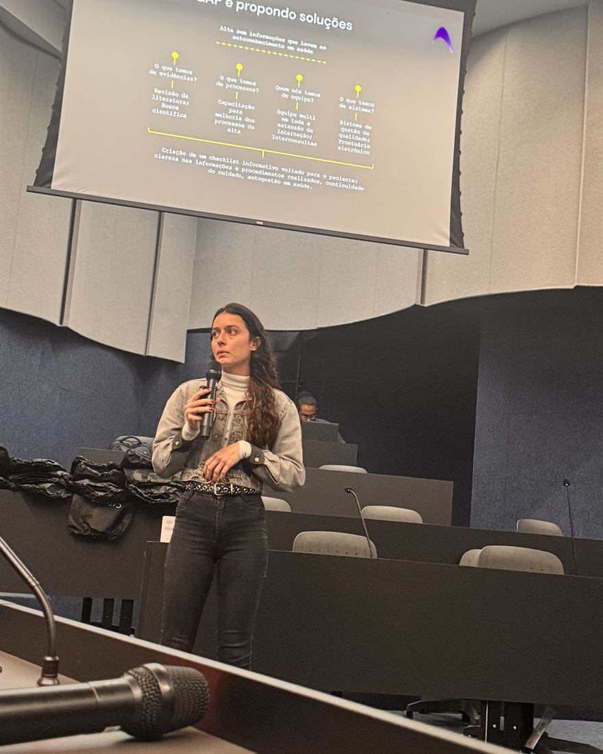 Participante apresenta ao microfone o projeto do seu time